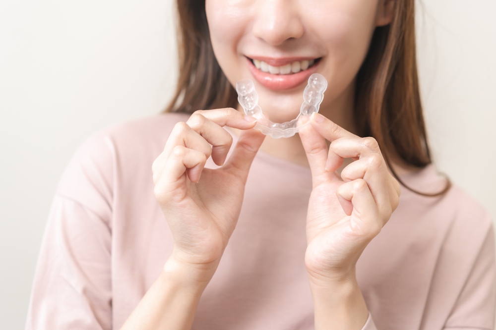 Dental,Invisible,Braces,,Beautiful,Smiling,Asian,Young,Woman,Holding,Invisalign